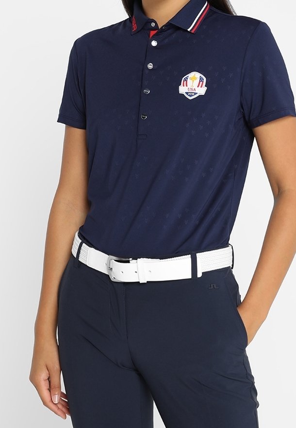 Mörkblå polo skjorta med korta ärmar, en kontrasterande röd och vit krage, och en broderad emblem på bröstet. Har en slim fit.