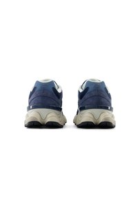 Navy blue sneakers with suede and mesh upper, accented by a beige sole and black tread. Features a padded collar and logo on heel.