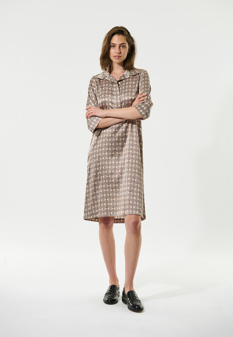 Kurzärmliges Kleid mit geometrischem Muster, ausgestattet mit einem Kragen und entspannter Passform, aus glattem Stoff in gedämpften Braun- und Cremetönen.