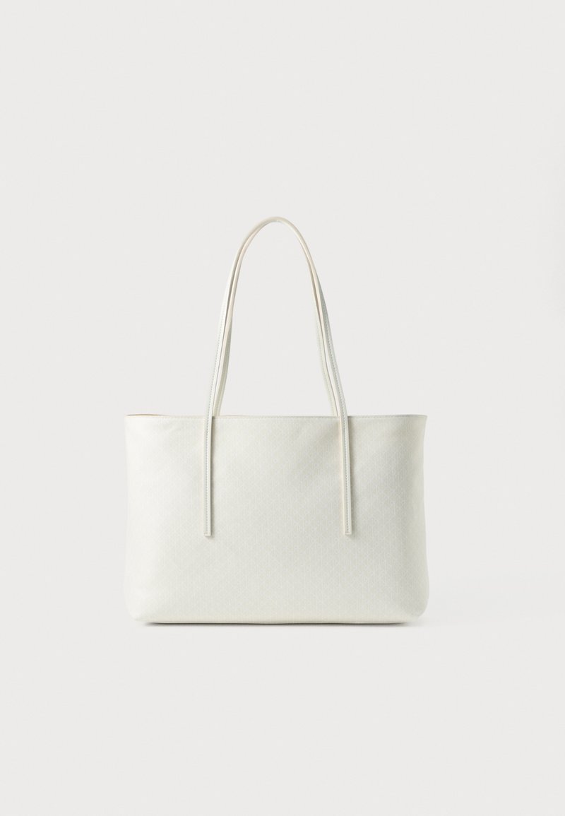 Crème-kleurige rechthoekige tote bag met lange slanke handvatten en een subtiel textuurpatroon op het gladde oppervlak.