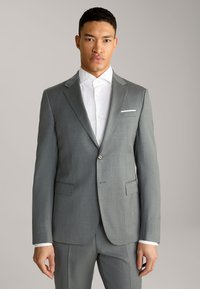 Grau anzugjacke aus einem strukturierten stoff, mit schalkragen, zwei vordertaschen und einem einknopfverschluss. Darunter ein weißes dresshemd.