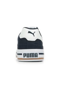 Sneaker in tela blu marina con colletto in pelle bianca, caratterizzato da un logo Puma nero e una suola in gomma bianca spessa con dettagli marroni.
