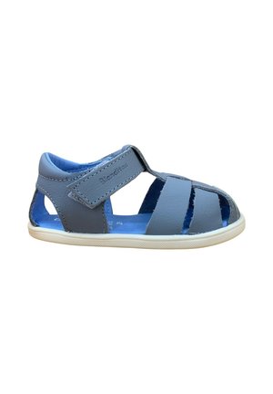 Sandalia azul para niño pequeño con puntera cerrada, tira de velcro y suela de goma blanca, hecha de material de cuero suave.
