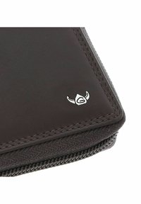 Gros plan d'un coin de portefeuille en cuir marron foncé avec des coutures détaillées, un bord de fermeture éclair en tissu, et un petit logo casques vikings argenté.