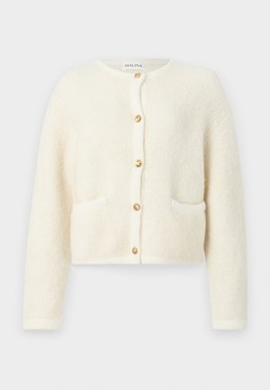 Hvit, fluffy cardigan med lange ermer, rund halslinje og gullknapper. Har to frontlommer. Myk tekstur med et koselig utseende.