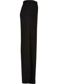 Pantalon noir à jambes droites avec taille élastique, poches latérales et une discrète fente en bas de chaque jambe.