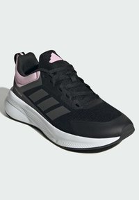 Schwarzer Sport sneaker mit einer Mesh-Oberfläche, pinken Akzenten, drei diagonalen Streifen an der Seite und einer weißen Außensohle mit strukturierten Details.