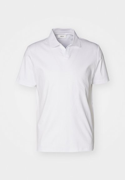 Hvid kortærmet polo-shirt med krave og et lille mærke inde i halsudskæringen mod en ensfarvet baggrund.