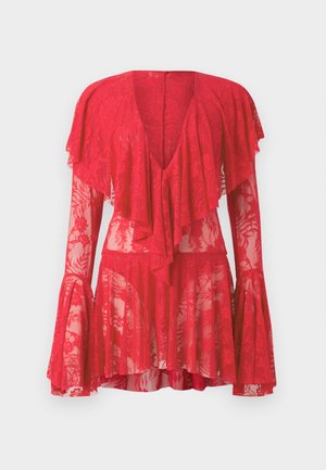 Vestido rojo de encaje con mangas largas acampanadas, escote en V profundo, volantes en capas y patrones florales. La textura transparente realza su diseño.