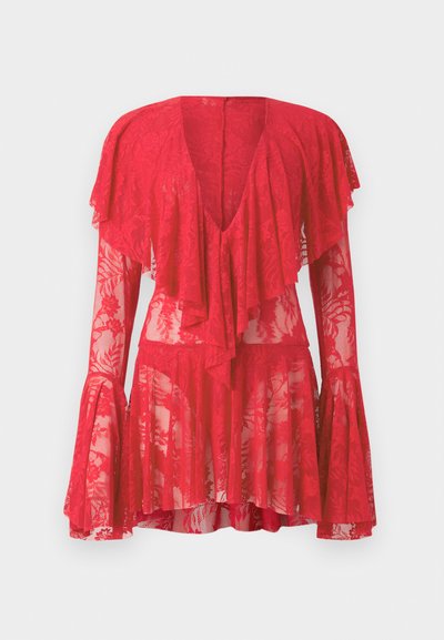 Piros csipkebársonyos ruha hosszú, bővülő ujjakkal, mély V-kivágással, rétegezett fodrokkal és virágmintával. A átlátszó textúra fokozza a dizájnt.