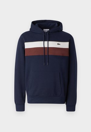 Marineblauwe hoodie met een voorzak in kangoeroestijl, voorzien van horizontale strepen in wit en roestkleur, en een klein logo op de borst.