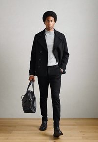 Abrigo de marinero negro sobre un cuello de tortuga gris, pantalones negros y zapatos negros. Llevando un bolso gris oscuro. Textura suave, diseño minimalista, aspecto moderno.