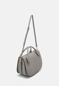 Grå läderhandväska med två handtag och ett justerbart rem. Funktioner i guldtonad hårdvara och en slät, texturerad yta.