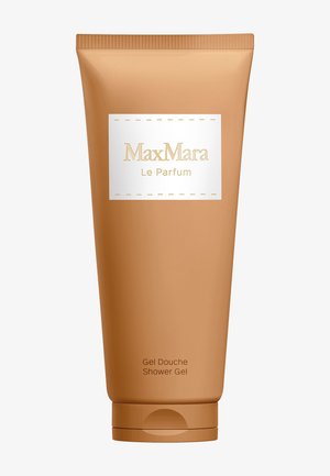 Tube beige de gel douche MaxMara Le Parfum avec étiquette blanche et texte doré sur fond uni.