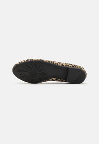 Sole di scarpa flat in stampa leopardata, con una base in gomma nera testurizzata e una parte superiore beige con un motivo, dalla forma arrotondata e design flessibile.