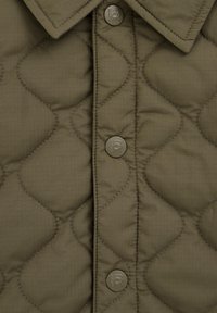 Olive green quilted jacket with a buttoned front, featuring rounded quilted patterns and a classic collar design.