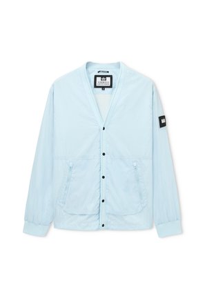 Hellblaue Jacke mit Knopfleiste, langen Ärmeln, zwei vorderen Reißverschlusstaschen, elastischen Bündchen und einem schwarzen Aufnäher am linken Ärmel.