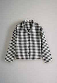 Fekete-fehér kétszínű kockás ing, hosszú ujjal, galléros, elöl gombos záródással, egyetlen mellzsebbel, pamut anyagból, dobozos fazonban.