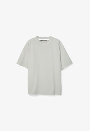 Lichtgrijs T-shirt met korte mouwen en ronde hals, met een klein subtiel logo op de linkerborst, plat weergegeven tegen een witte achtergrond.
