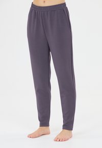 Grå, stretchiga joggarbyxor med elastisk midja och sidofickor. Slät yta och avsmalnande ben design. Lätt material.