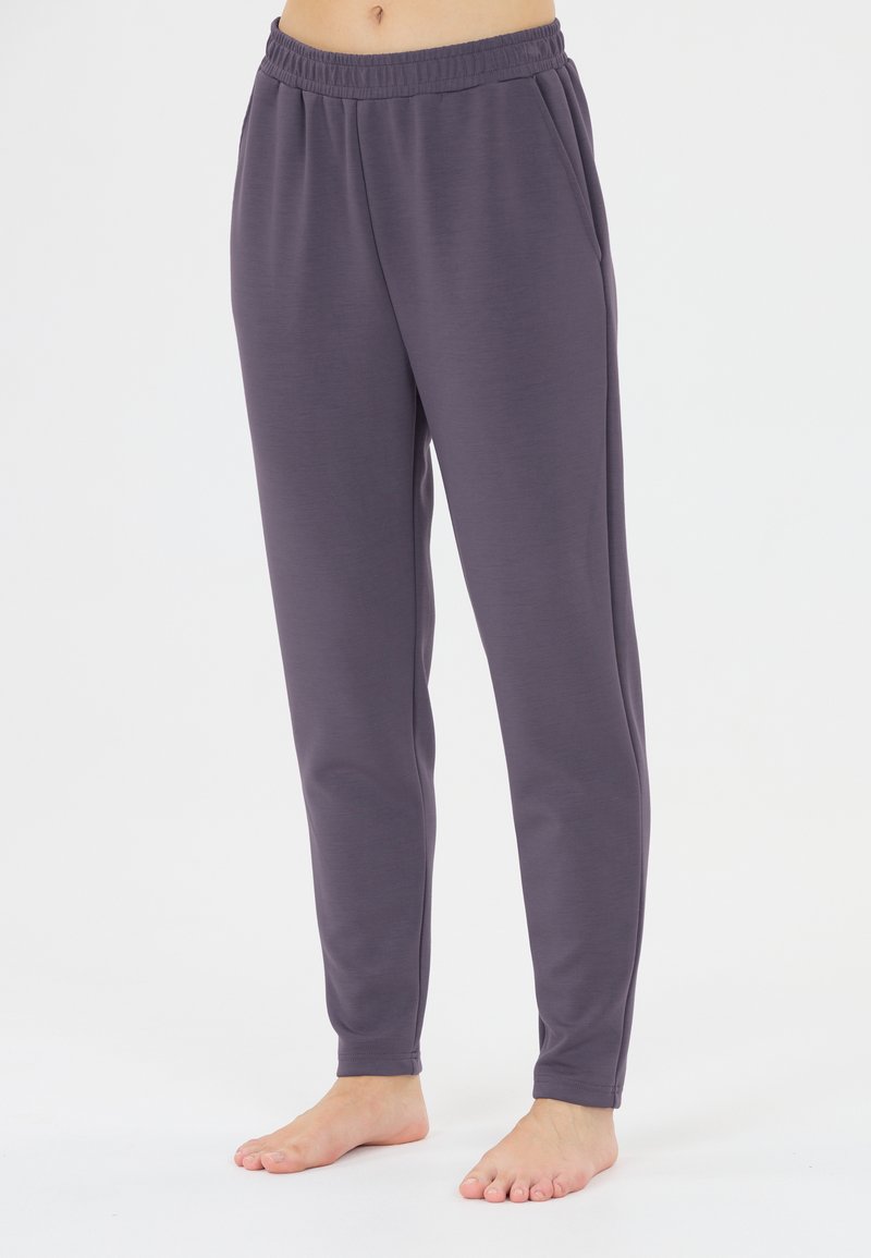 Grå, stretchiga joggarbyxor med elastisk midja och sidofickor. Slät yta och avsmalnande ben design. Lätt material.