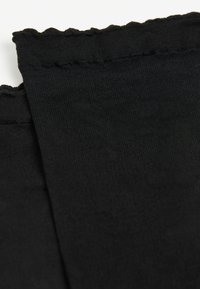 Tela negra con una textura suave, que presenta un borde ondulado. Superficie lisa con un ligero brillo reflectante y sin patrones visibles.