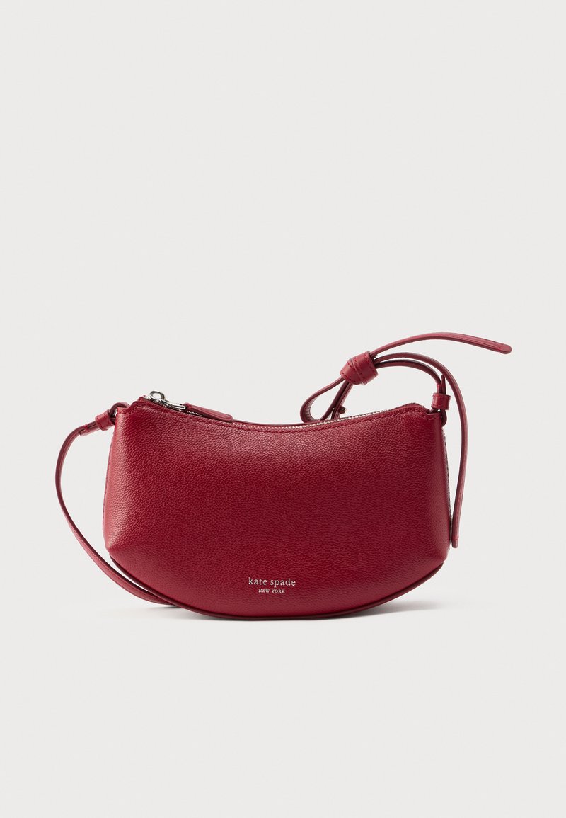 Rdeča usnjena torbica čez ramo z zaobljeno obliko, zadrgo za zapiranje in nastavljivim trakom. Na sprednji strani je vtisnjen logotip. Gladek tekstura.