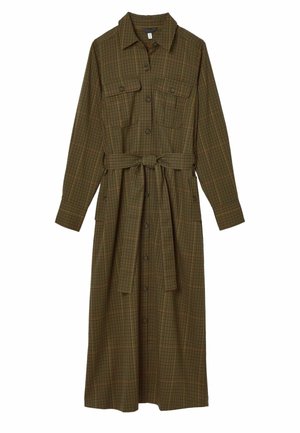 Langärmliges, geknöpftes Kleid aus dunklem, kariertem Stoff mit gebundenem Taillenbund, seitlichen Taschen und knöchellanger Passform. Getragen mit braunen Loafers.