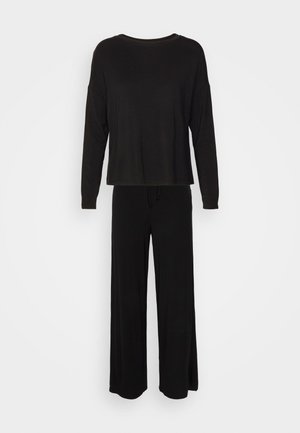 Schwarzes Langarmoberteil mit Rundhalsausschnitt, kombiniert mit passenden weit geschnittenen Hosen, beide aus einem weichen, glatten Stoff gefertigt.