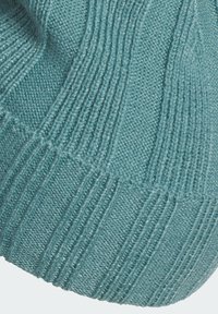 Bonnet tricoté en bleu sarcelle doux ; présente une texture côtelée avec des rangées alternées de mailles lisses et de mailles texturées. Haut arrondi, ajustement élastique.