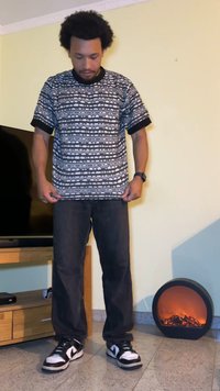 Tricou cu model alb și negru, cu mâneci scurte, guler rotund și margine neagră. Asortat cu blugi negri și adidași negri.