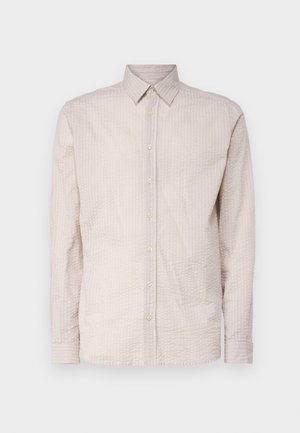 Helle beige Langarm-Bluse mit Knöpfen und strukturiertem Muster, ausgestattet mit einem Kragen und passenden Knopfdetails auf der Vorderseite.