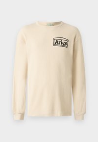Chemise à manches longues couleur crème avec texture côtelée, col rond et logo noir "Aries" sur la poitrine gauche. Manches à poignet.