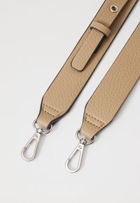 Cinturino in pelle beige con superficie texturizzata, caratterizzato da fermagli in metallo argentato e un passante in pelle abbinato. Bordo a contrasto lungo i lati.
