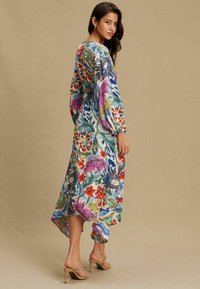 Daudzkrāsaina ziedu maksi kleita ar garām piedurknēm, augstu-zemu apakšu un vieglu audumu. Izceļas ar košiem rakstiem un ērtu pieguļojumu.