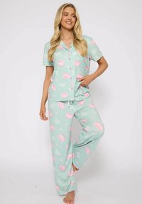 Lichtgroene pyjama set met een shirt met korte mouwen en lange broek, met roze koffie kop en hart patroontjes, gemaakt van zachte stof.