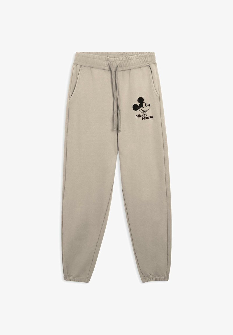 Pantaloni jogger beige realizzati in tessuto morbido, dotati di tasche laterali, elastico in vita con cordoncino e logo di Topolino nero.