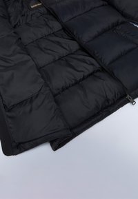 Czarna, ocieplona kurtka z pikowanym wzorem, z zamkiem błyskawicznym i miękką podszewką. Lekki materiał, odpowiedni na zimne dni.