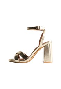 Gold metallic high-heeled sandal with an open toe, adjustable ankle strap, wide block heel, and crossed front straps. Smooth texture.