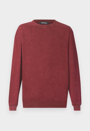 Burgundska jopa z dolgimi rokavi, okroglim izrezom, rebrastimi manšetami in spodnjim robom, izdelana iz mehke tkanine z rahlo teksturo. Vidna je tudi etiketa znamke.