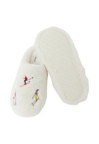 Białe kapcie z futerka ekologicznego z haftowanymi postaciami narciarzy, posiadające teksturowaną gumową podeszwę dla lepszej przyczepności oraz zaokrąglony kształt.