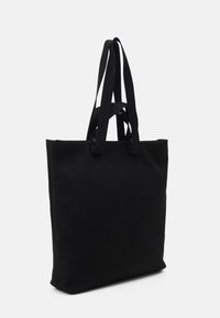 Borsa tote in tela nera con doppi manici a spalla. Texture liscia, forma rettangolare, design minimalista, con dettagli del logo sui manici.