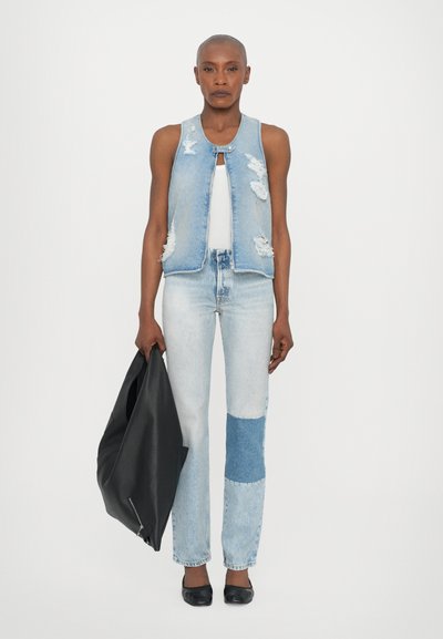 Denim vest, svetlo modra, obrabljena zasnova; bela majica brez rokavov; svetlo modri kavbojke s krpami; črna usnjena torba; črne balerinke.