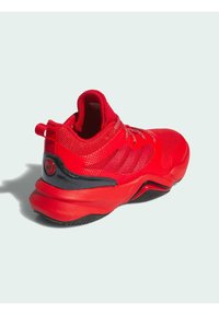 Roter Sportschuh mit einem strukturierten Mesh-Obermaterial, gepolstertem Kragen und einem schwarzen Akzent an der Ferse mit einem Logo. Leichte Gummisohle für besseren Halt.