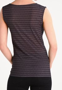 Mörkt ärmlöst linne med ett litet, upprepande blommönster och en slät textur. Bakifrån visas en rundad halsringning och en figurnära design.