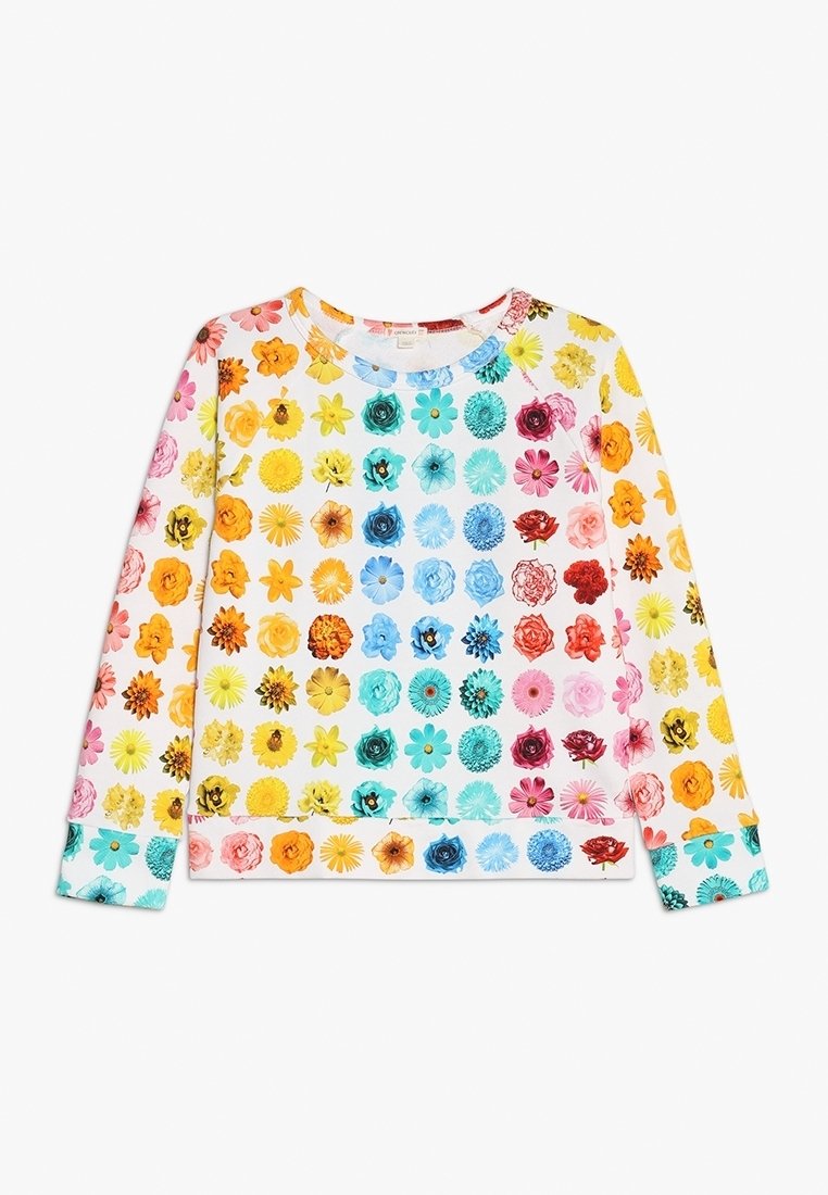 Haut blanc à manches longues avec des rangées multicolores de divers motifs floraux couvrant tout le vêtement.