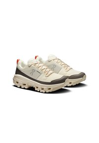 Lightweight running shoes in cream with gray accents. Features textured mesh upper, durable rubber sole, and orange heel tab. Lace-up design.