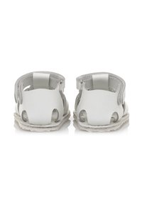 Sandalias de cuero blanco con un diseño abierto, que presentan cortes, correas ajustables en el tobillo y una suela texturizada.