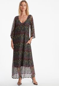 Maxi-jurk met zigzagpatroon in meerdere kleuren, met een V-hals, driekwartmouwen en twee zijzakken. Gemaakt van doorschijnende stof.