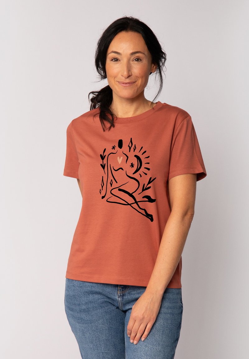 Roodbruine t-shirt met korte mouwen, gemaakt van katoen, met een zwart abstract ontwerp van een zittende figuur omringd door geometrische vormen.